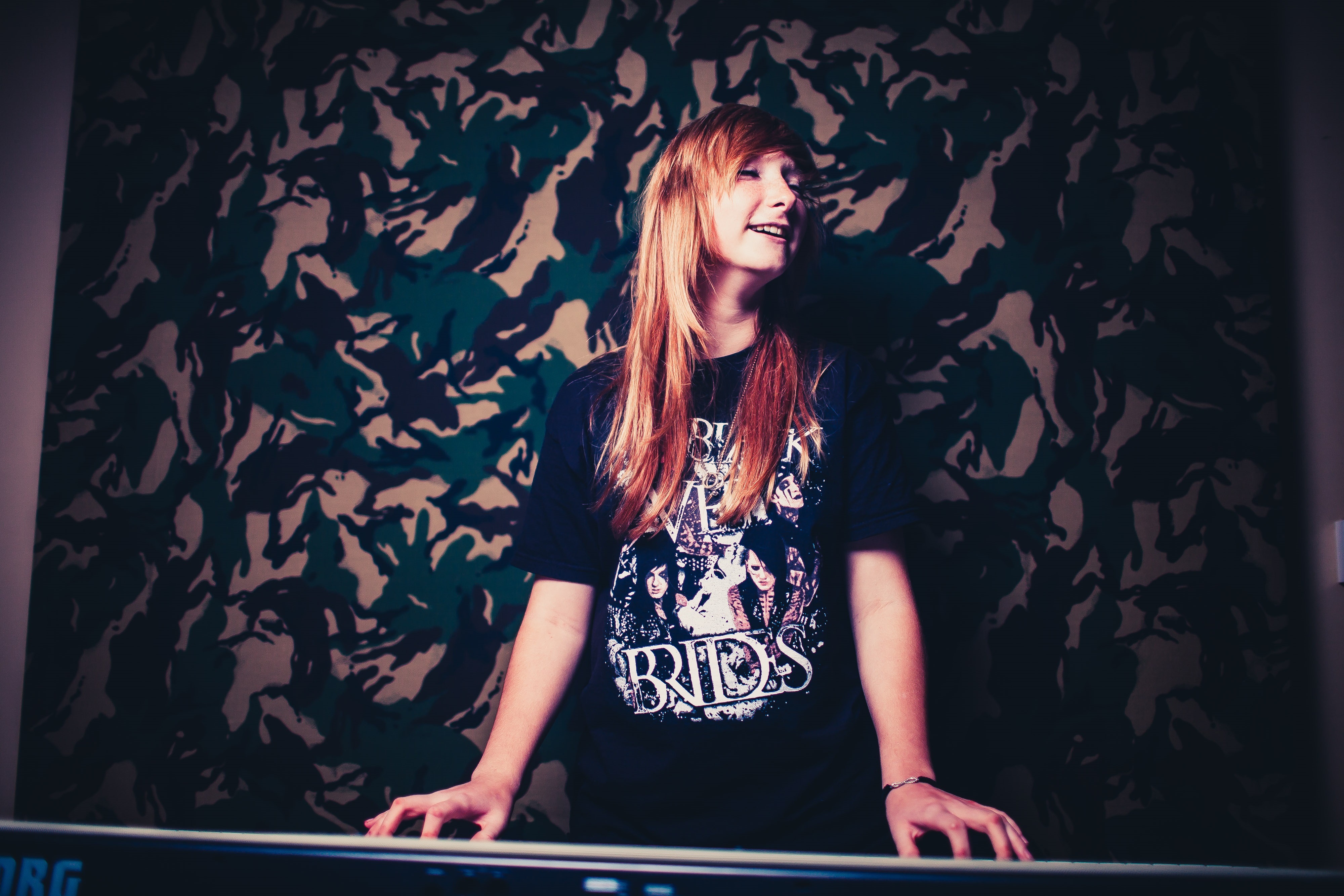Young person with long red hair playing the keyboard