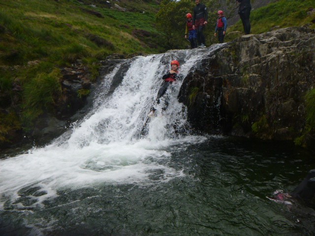 Young people navigating a waterfall in Wales on a Pie Factory Music residential activity trip to Arete Outdoor Centre.
