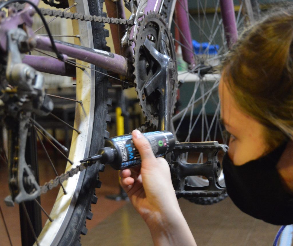 Young person oiling a bike chain at Pie Factory Music HQ
