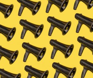 A series of black megaphones on a yellow background